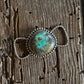 Silver twilly slide with a turquoise stone on a wooden surface
