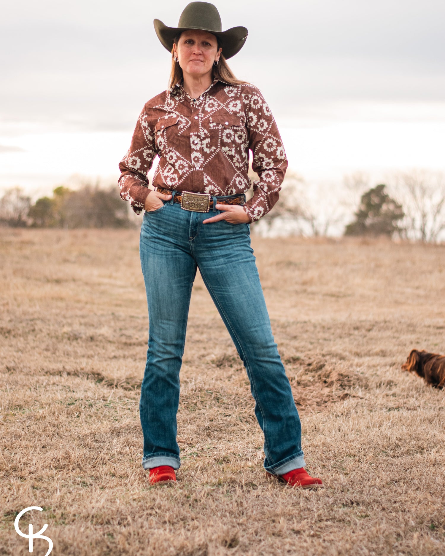 model standing in field wearing a fashionable modern western outfit