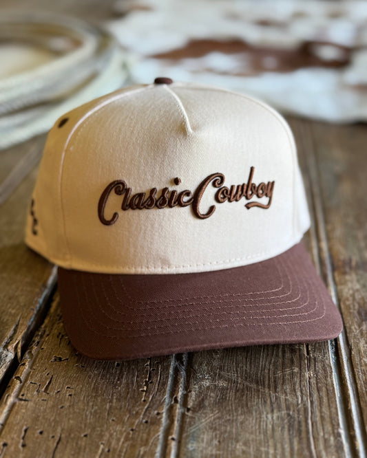 Beige and brown cap with 'Classic Cowboy' text on a wooden surface