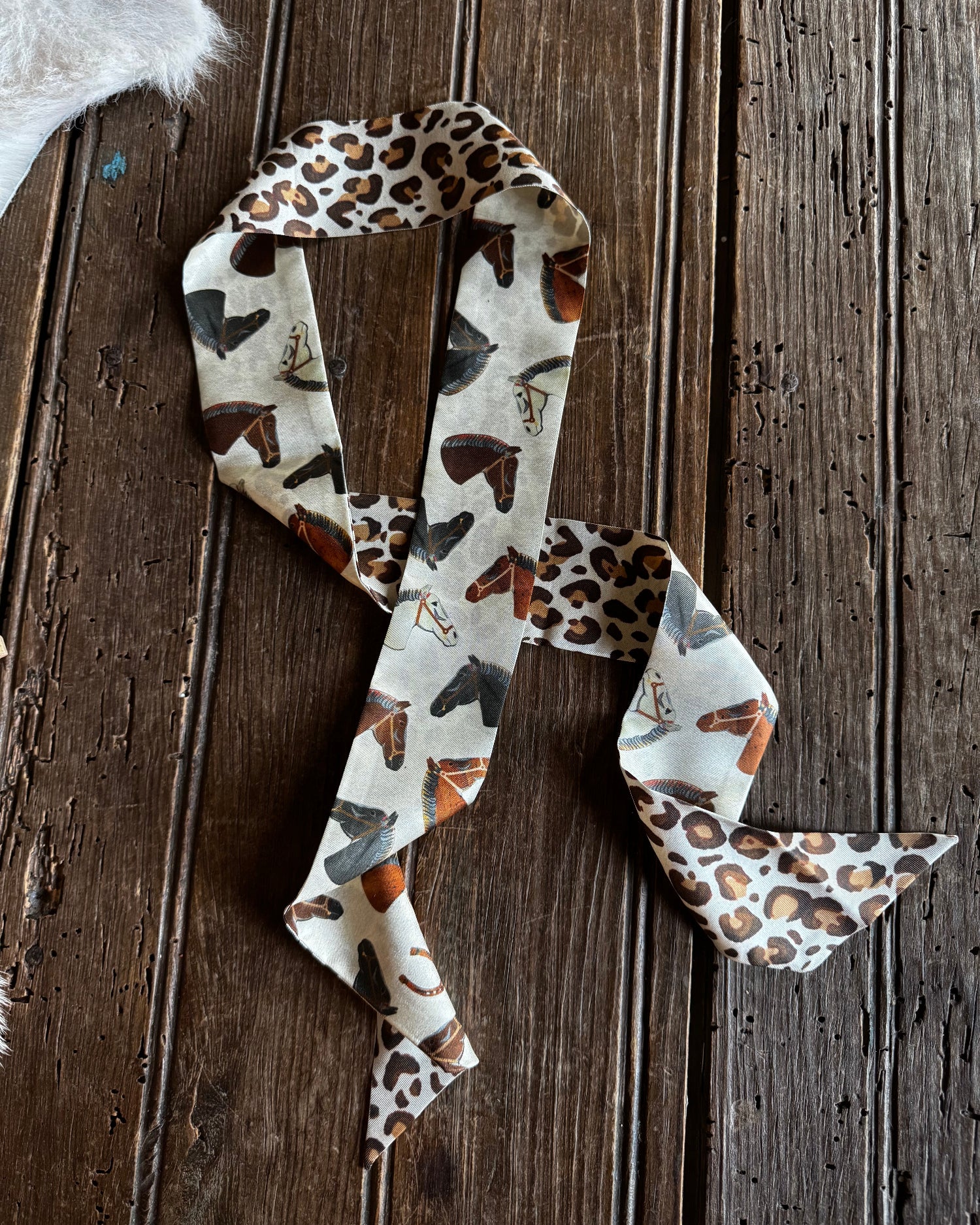 leopard and horse print twilly scarf on a wooden background
