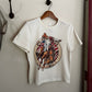 White t-shirt with a colorful graphic design on a white surface