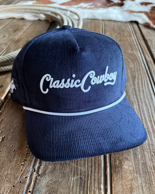 Navy blue cap with 'Classic Cowboy' text on a wooden surface