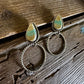 earrings with royston stones on a wooden surface