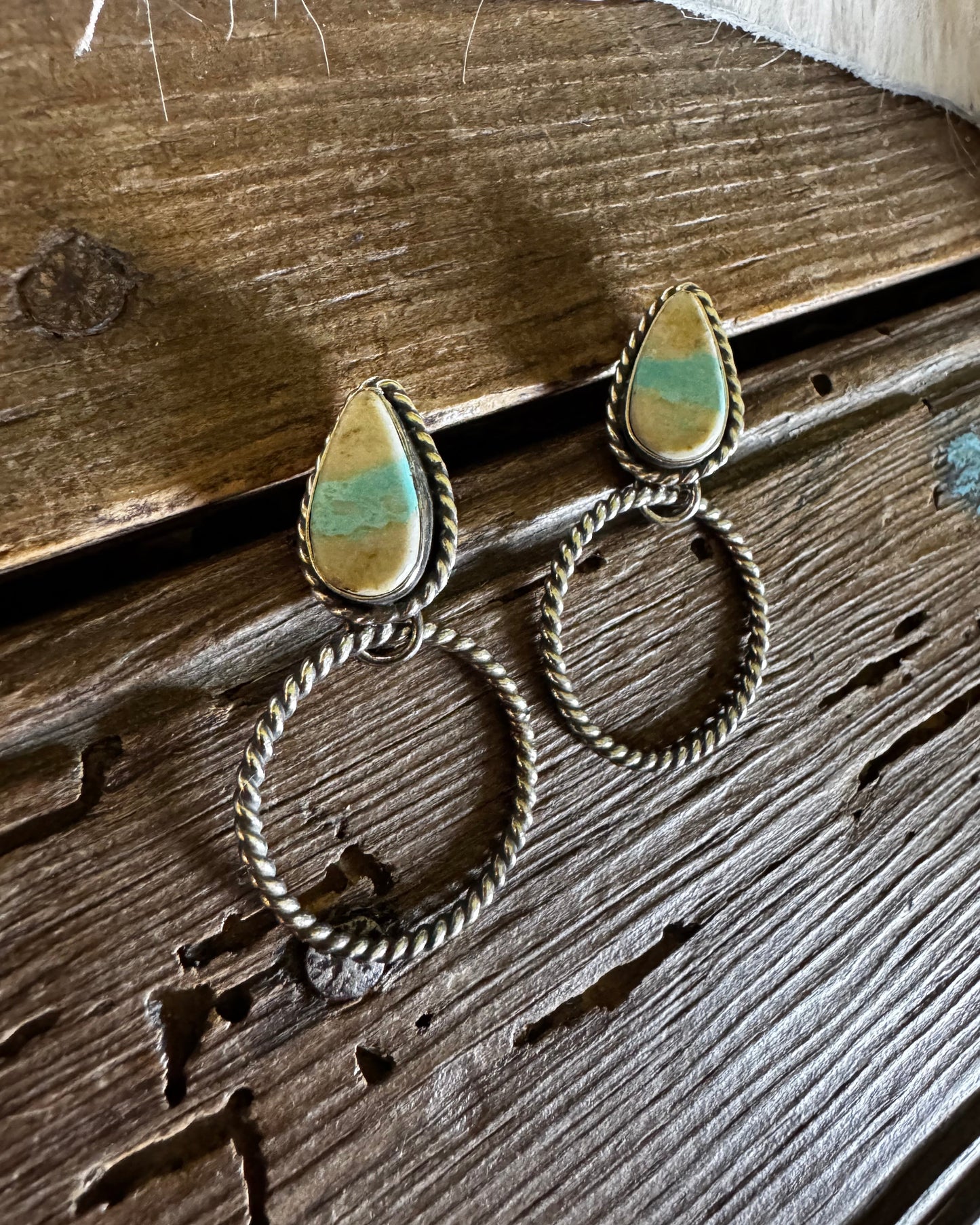earrings with royston stones on a wooden surface