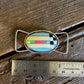 twilly slide with colorful design on a wooden surface next to a ruler for scale.