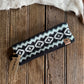 Knitted headband with a geometric pattern on a wooden surface with fur in the background