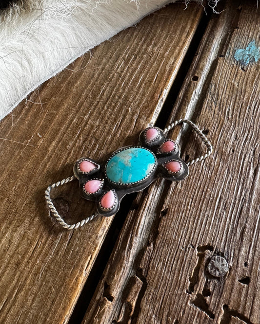 Twilly slide with turquoise and pink conch on rustic wooden surface