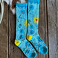 Pair of blue socks with floral patterns on a wooden surface