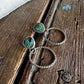 Jewelry set with green gemstones on a wooden surface
