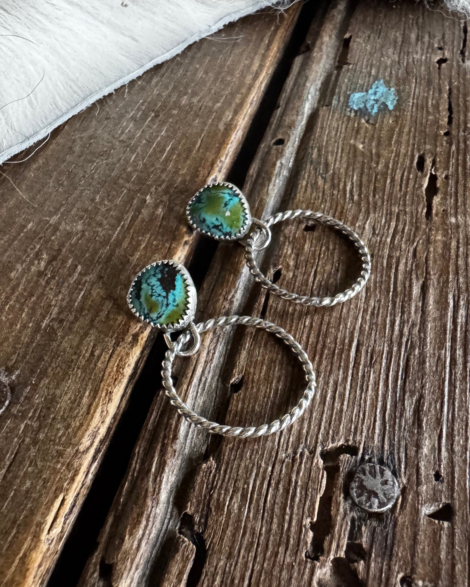 Jewelry set with green gemstones on a wooden surface