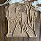 Beige tank top with branding on a wooden surface
