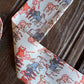 close up of ribbon scarf with horses on a rustic wood background