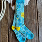 Pair of blue socks with floral designs on a wooden surface