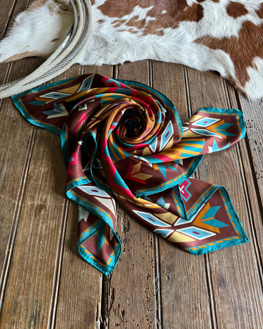 scarf folded on a rustic wood background with a cowhide and rope