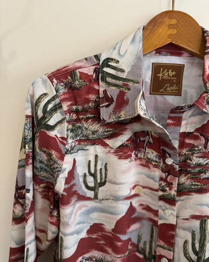 Floral patterned shirt with cactus design on a hanger against a white background