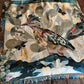 Collage scarf with feathers and nature-themed elements on a wooden surface