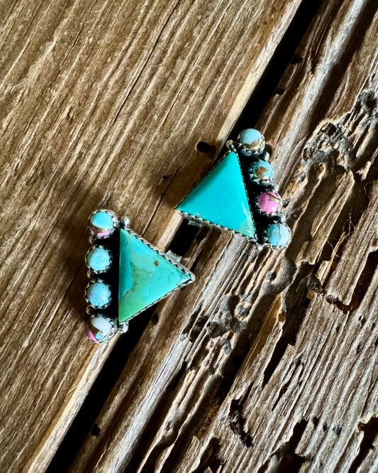 Turquoise triangle-shaped earrings on a wooden surface