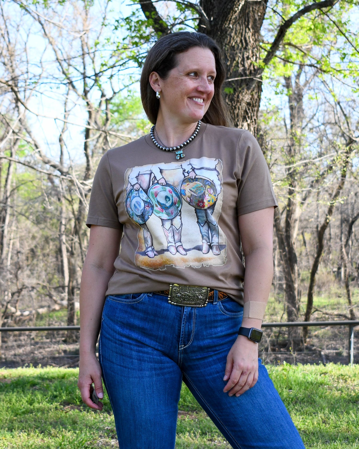 Cowgirls & Cowboy Hats Tee on model with wooded background 