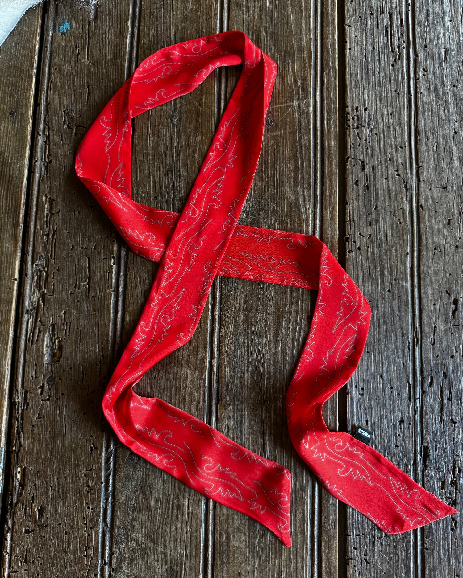 Red patterned scarf on a wooden surface
