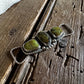 Twilly slide with green stones on a wooden surface