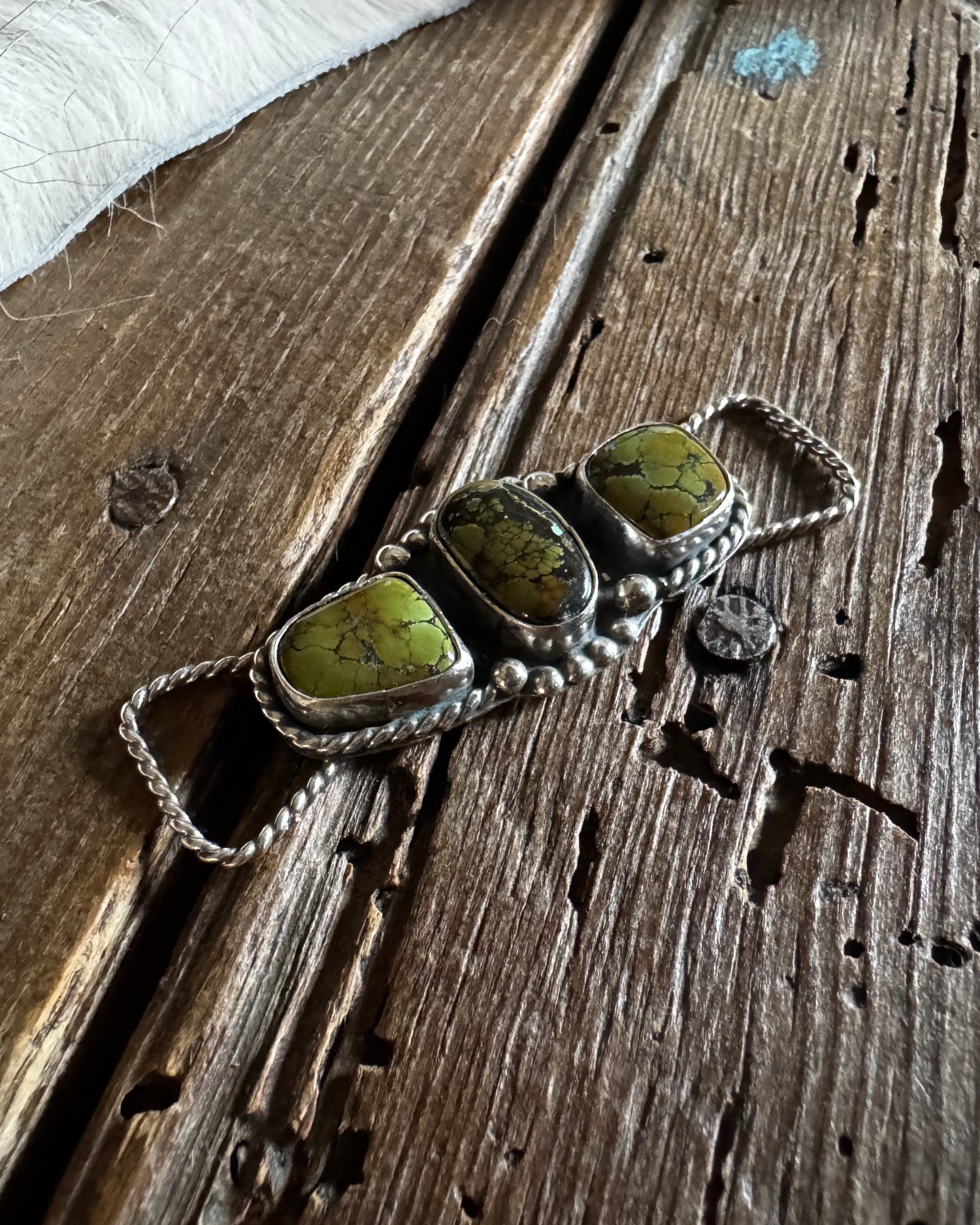 Twilly slide with green stones on a wooden surface