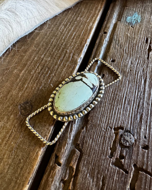 Necklace with a blue stone pendant on a wooden surface
