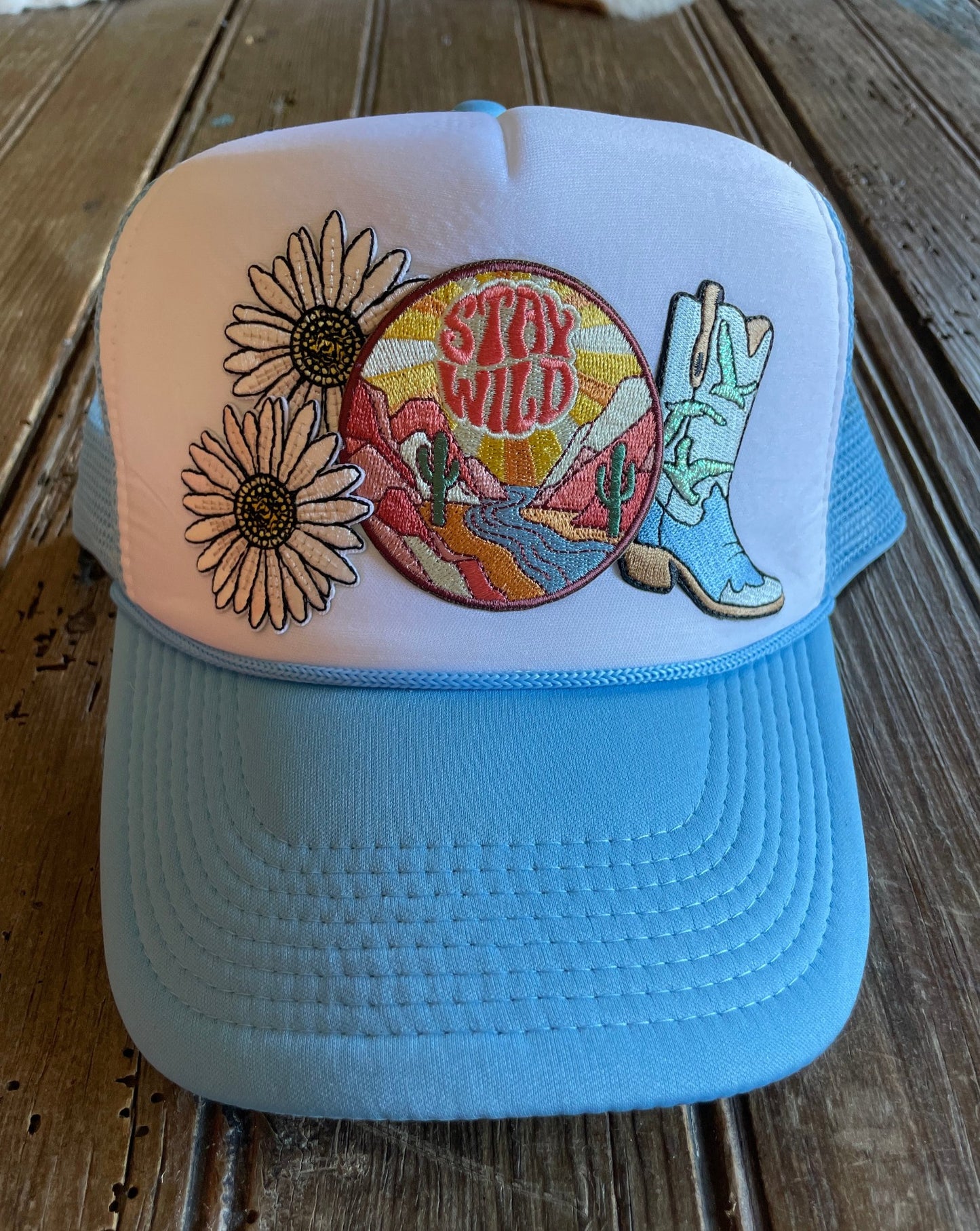 Front view of Stay Wild Daisy trucker hat with custom patches