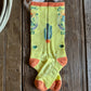 Colorful sock with text and designs on a wooden surface