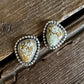Pair of decorative earrings on a wooden surface