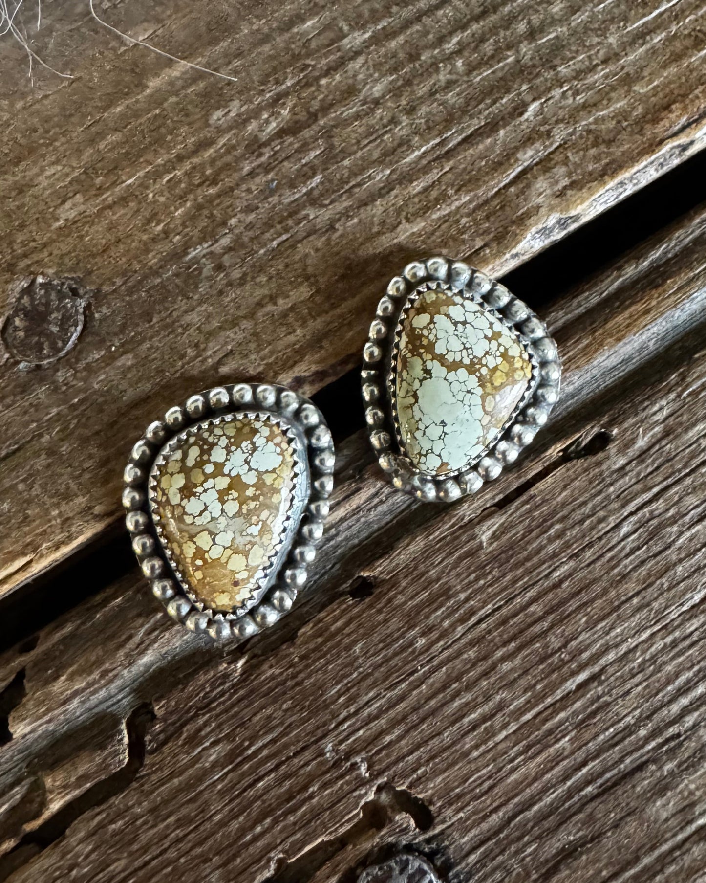 Pair of decorative earrings on a wooden surface