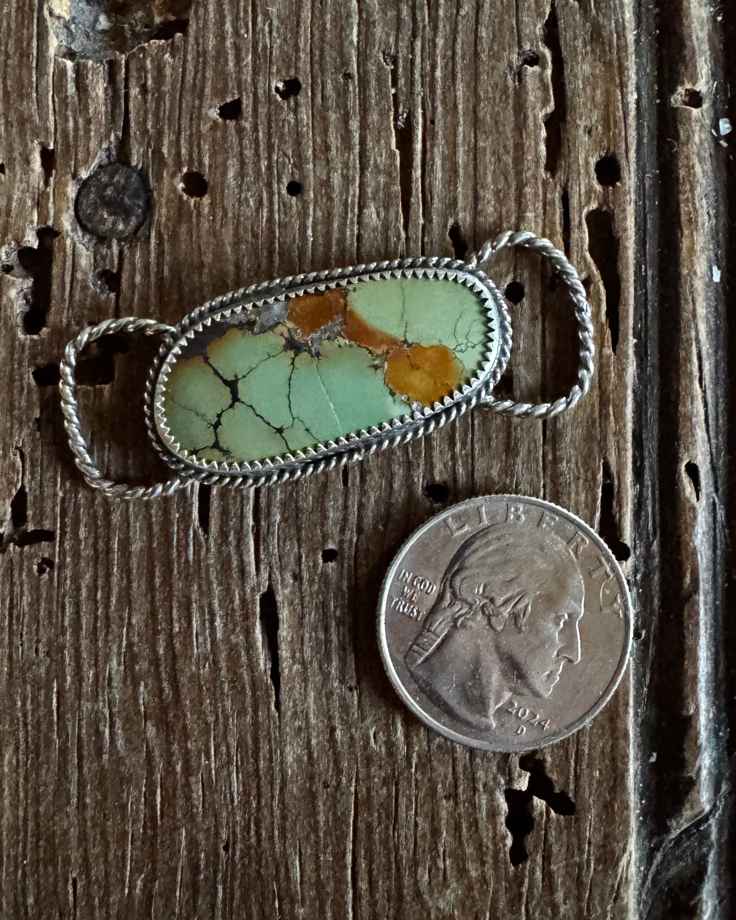 Hubei Turquoise scarf slide on a rustic wooden background with a quarter