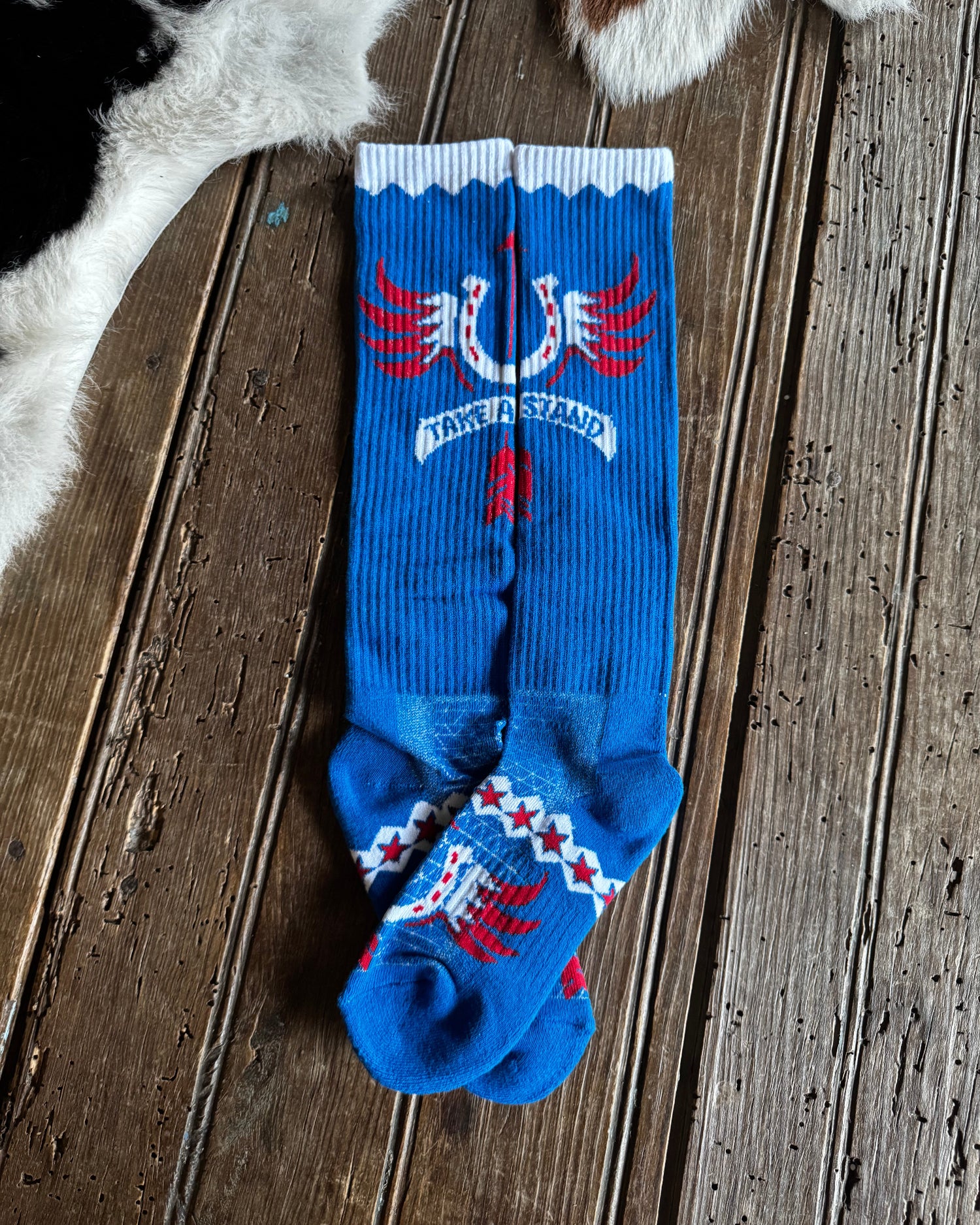 Blue socks with red and white designs on a wooden surface