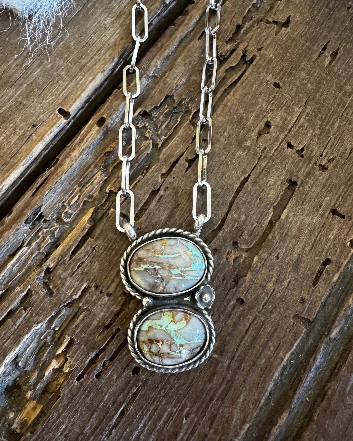 Necklace with two oval stones on a wooden surface