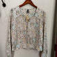 Floral-patterned shirt on a hanger against a white background