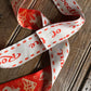 Decorative ribbon with red text and patterns on a wooden surface