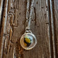 Necklace with a circular pendant on a wooden surface