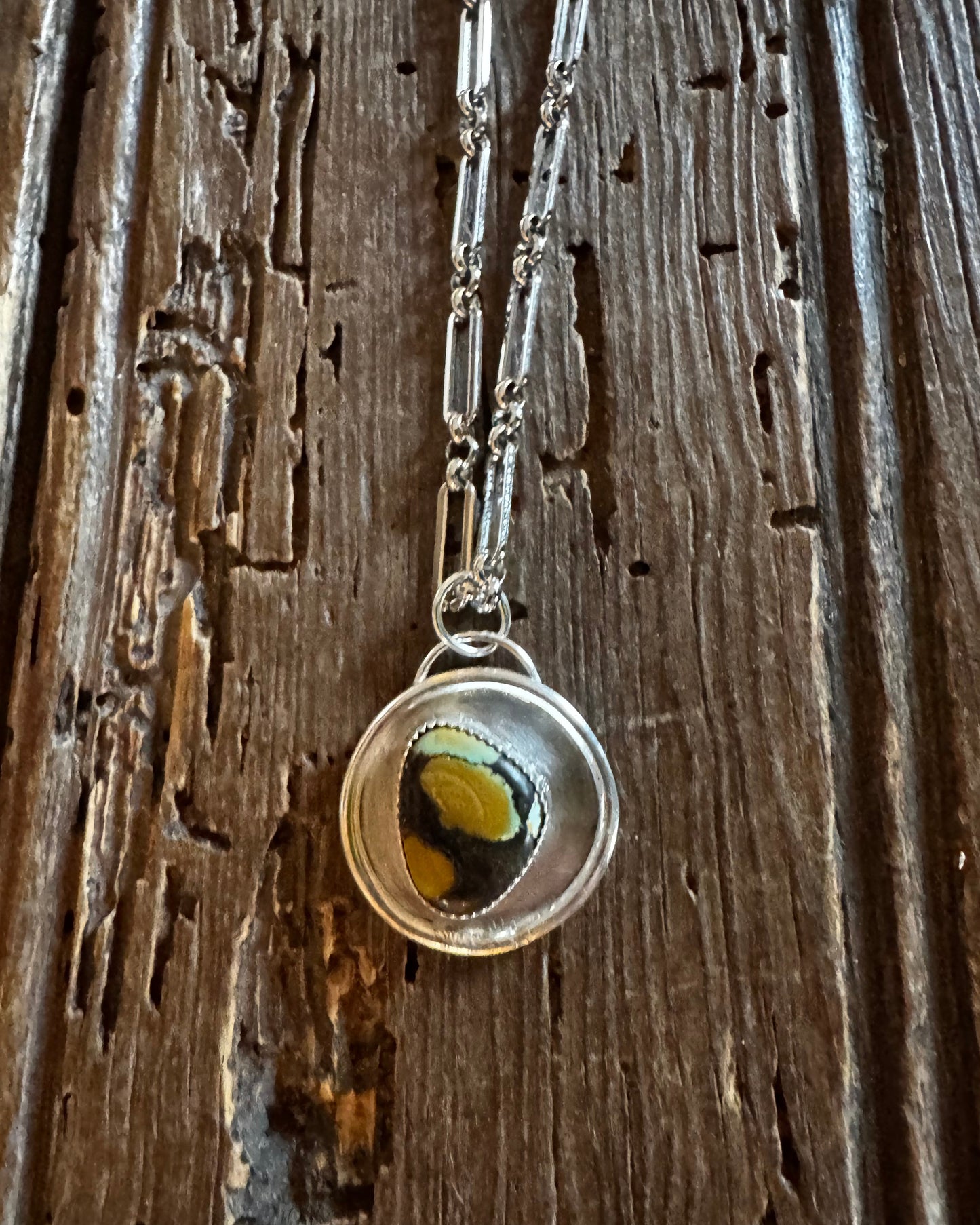 Necklace with a circular pendant on a wooden surface