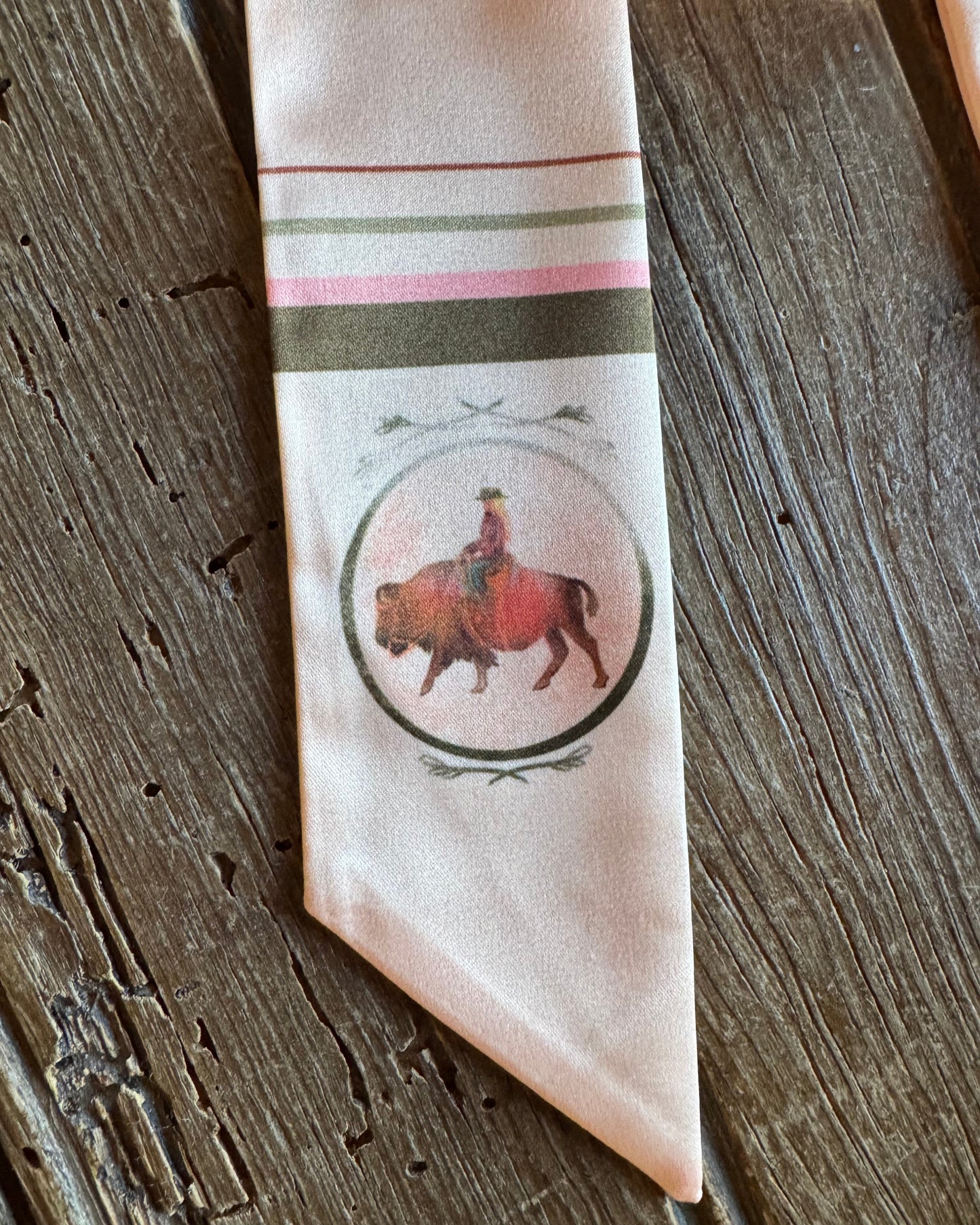 Close up of buffalo on a ribbon scarf on a rustic wood background 