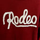 Red sweater with 'Rodeo' text on a white background