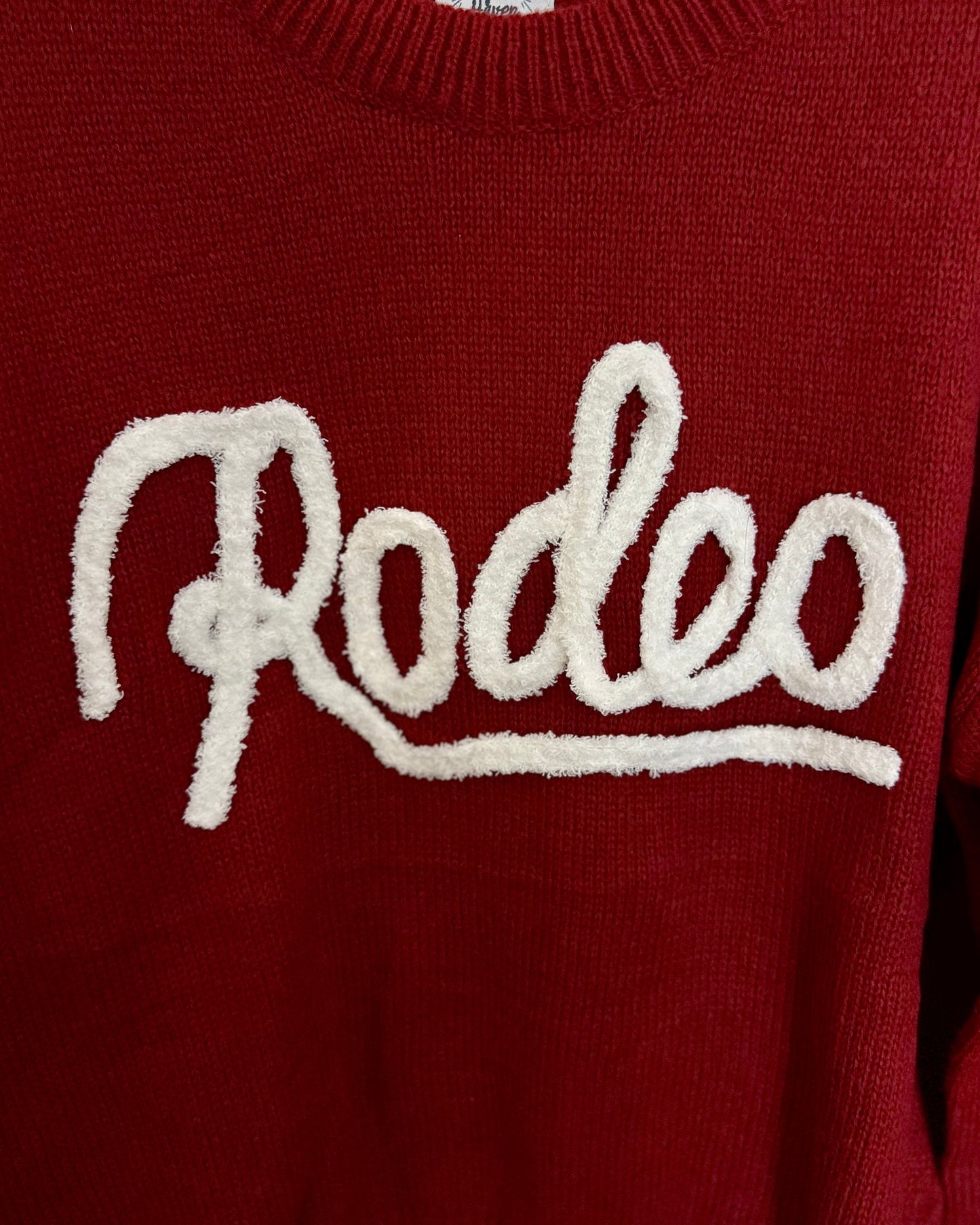 Red sweater with 'Rodeo' text on a white background