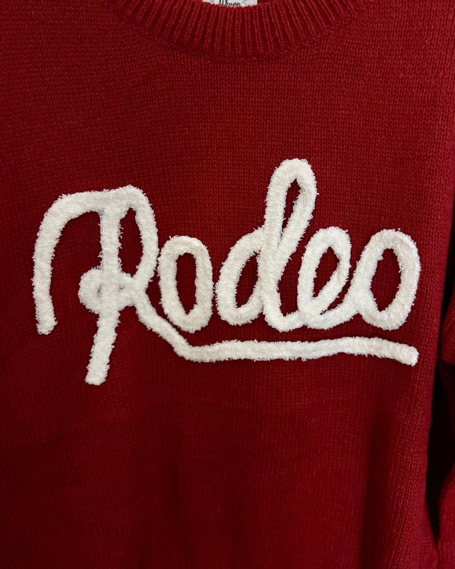 Red sweater with 'Rodeo' text on a white background