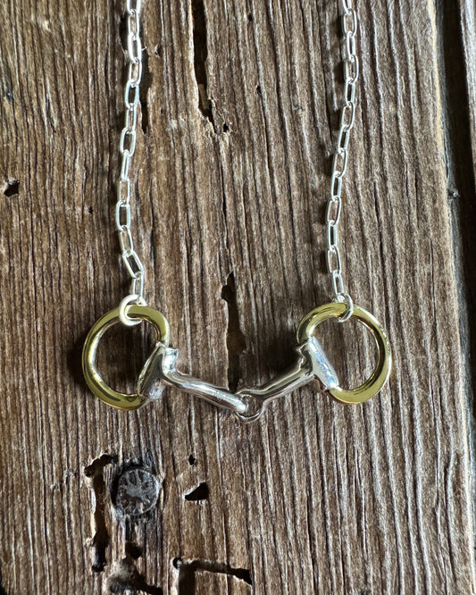 close up of Briarwood Snaffle Bit Necklace on rustic wood background 