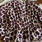 Floral print top on a wooden surface with a cowhide rug in the background
