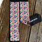 A pair of crew socks with a colorful repeating pattern of cartoon pigs on a white background, finished with solid black cuffs and toes. One sock is laid flat showing the pattern, while the other is folded to show the black sole with white text reading 'BARN SOCKS'.