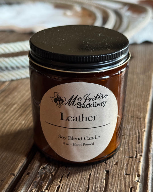 Jar of leather-scented candle on a wooden surface