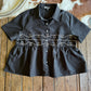 Black blouse with decorative embroidery on a wooden surface