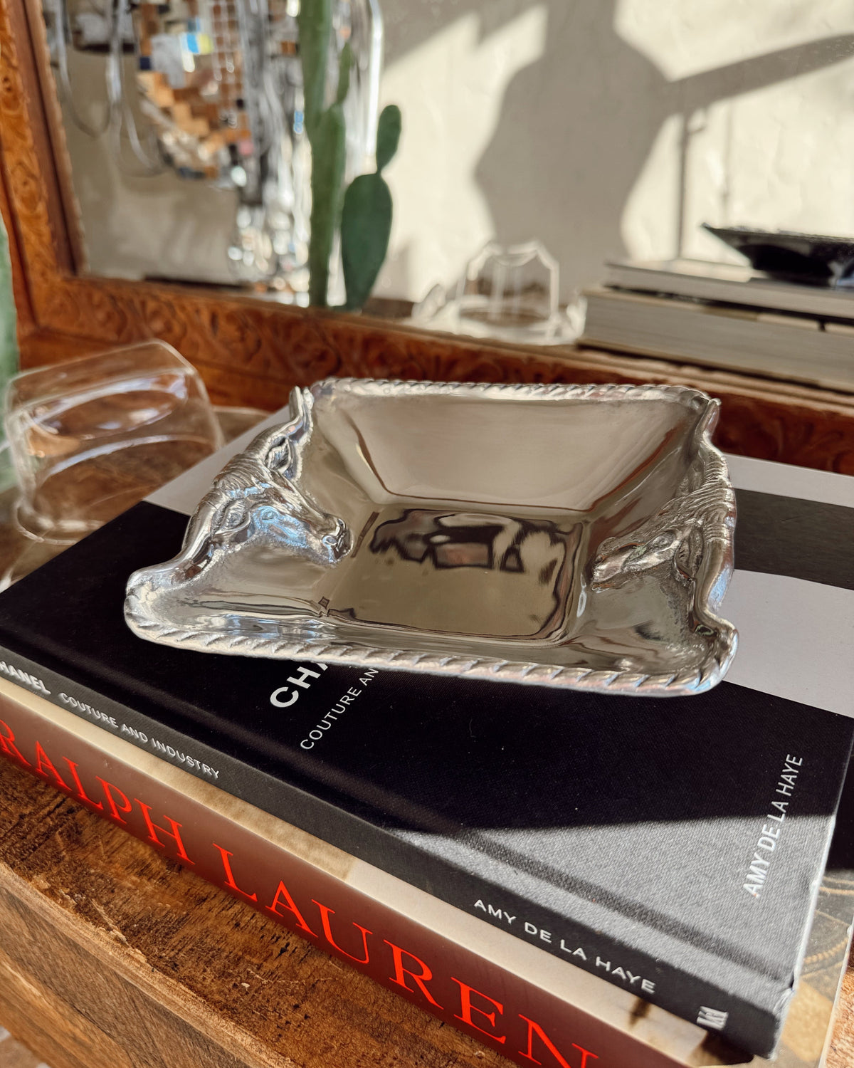 Silver dish on top of a book with a blurred indoor background