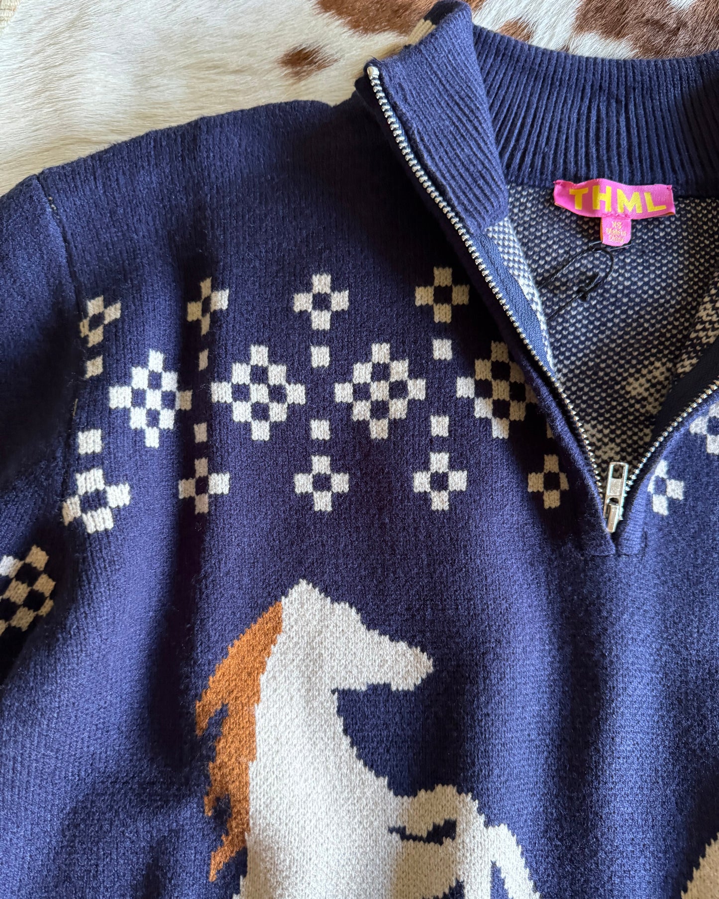 Close-up of a blue sweater with geometric patterns on a textured surface