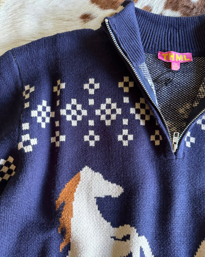 Close-up of a blue sweater with geometric patterns on a textured surface