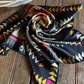 Colorful patterned scarf on a wooden surface